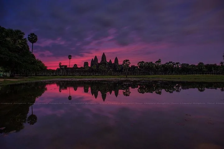 Angkor Wat temple silhouette at sunrise with vibrant pink sky reflection